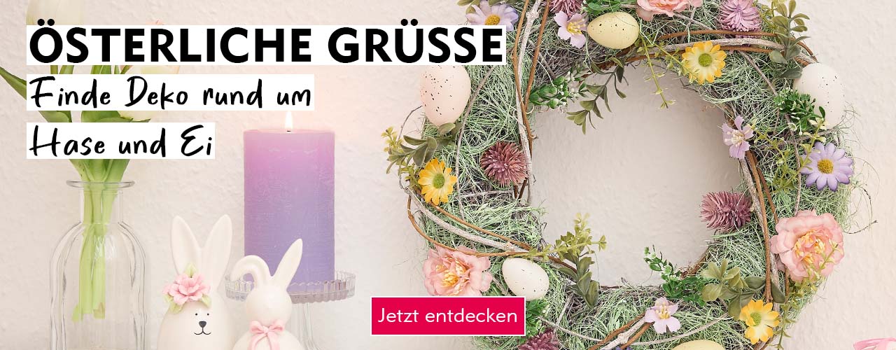 Entdecke Osterdeko bei Nanu-Nana Ein österlicher Deko-Kranz it zwei Keramikhasen und einer Kerze verlinkt auf die Kategorie Osterdeko