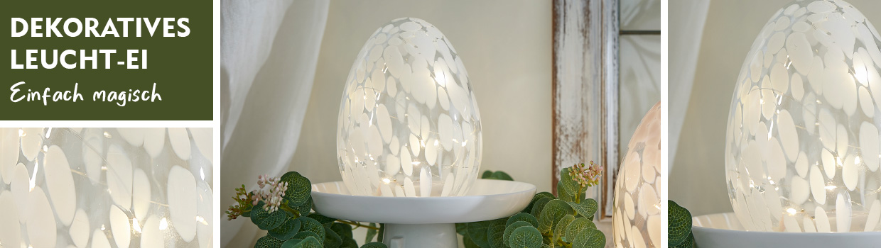 Leuchtendes Deko-Ei auf einem wei&szlig;en Deko-Teller wird pr&auml;sentiert